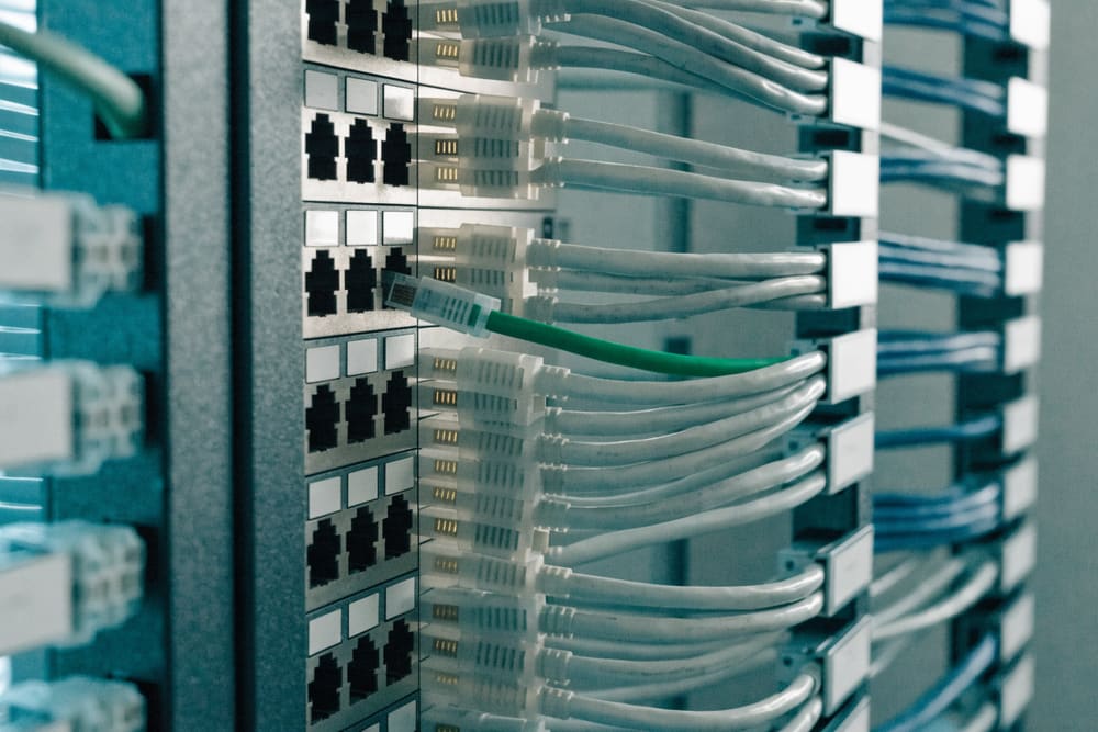 A patch panel with dozens of network cables combed and dressed into clean horizontal runs.